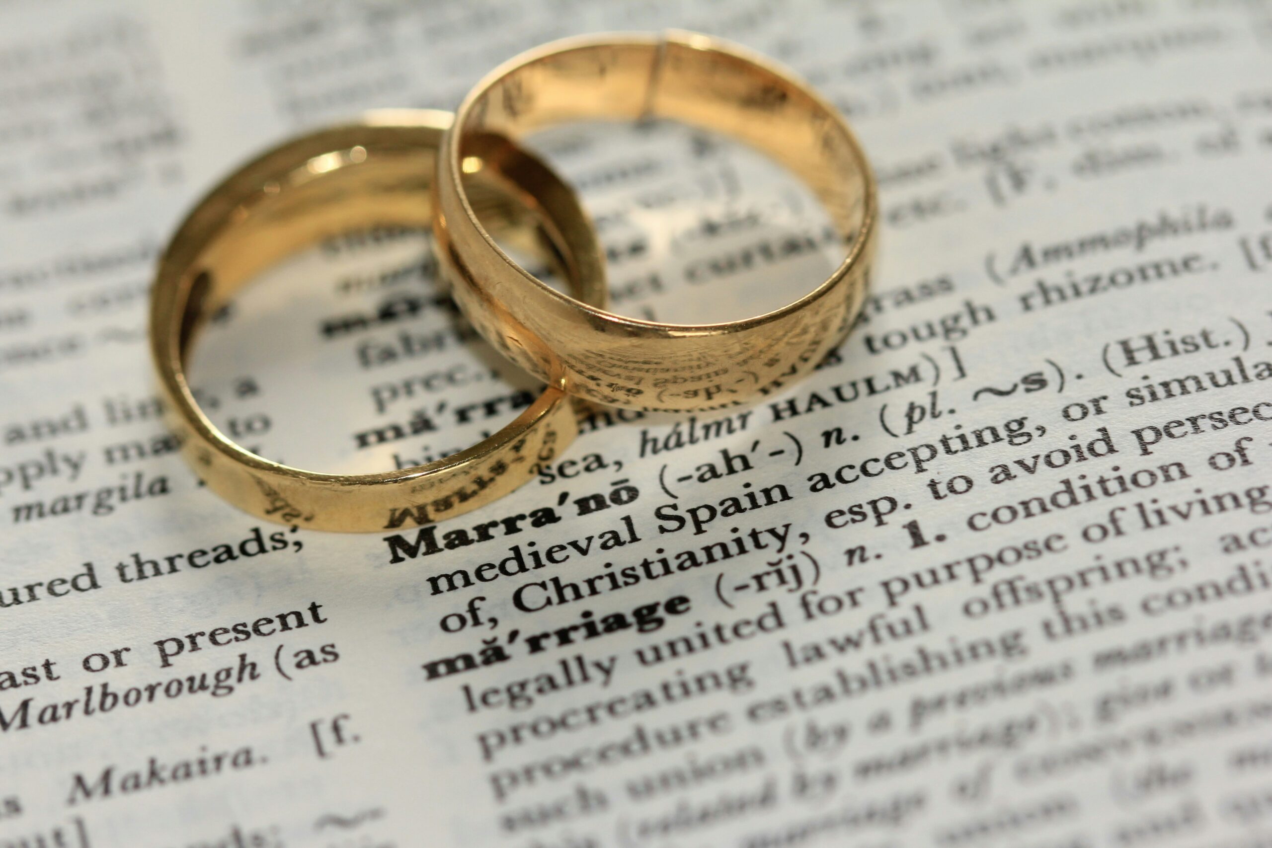 wedding rings hovering over written text about married live